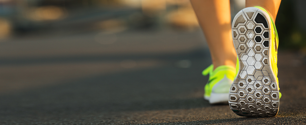 Village Physio & Sports Injury Clinic - closeup image of a runners shoes from behind going away from the camera